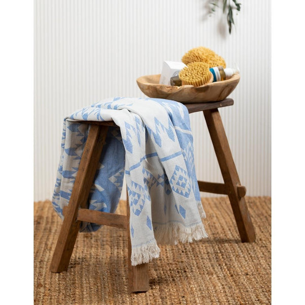 Image of Belize hammam towel in blue, draped over a bathroom stool.