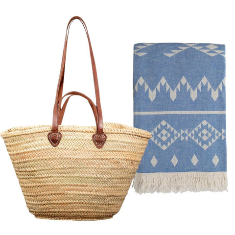 Bestseller bundle of a woven straw basket bag with long brown leather handles and a blue patterned hammam towel on a white background