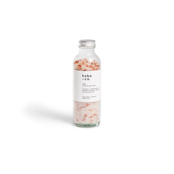 Glass bottle of hobo + co. bath salts on a white background