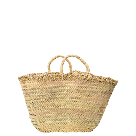 Image is of a straw basket with short handles and a woven straw lattice detail around the top. It is hndwoven by Moroccan artisans from palm leaves and is perfect for holidays, days out or as gorgeous rustic storage for your home.