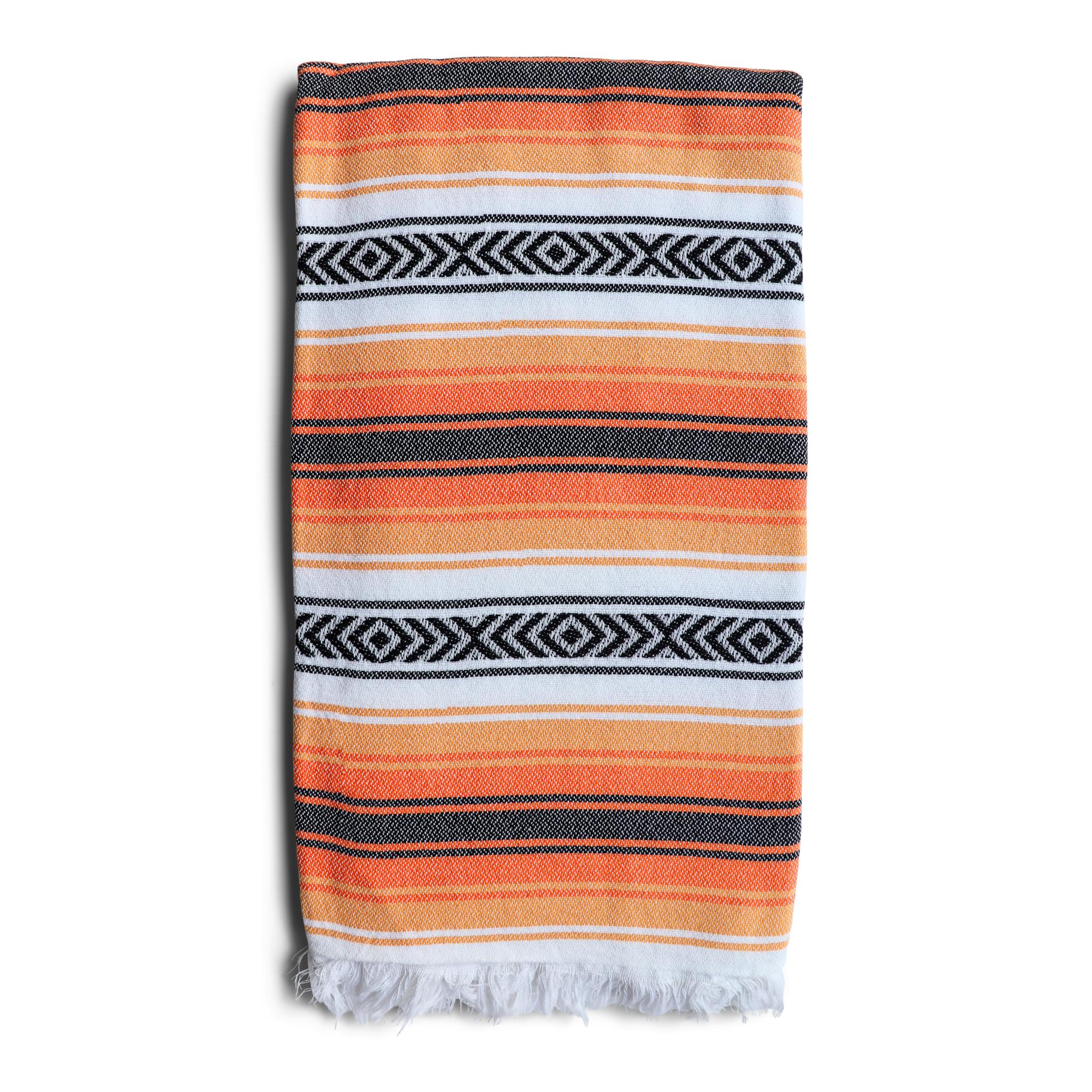 image of Playa hammam towel with orange and black stripes on a white background. Sold by Sand and Salt.