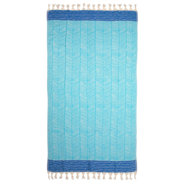 image of Skiathos hammam towel with a turquoise and cobalt blue design on an off-white background. Fringing at both ends. Sold by Sand and Salt.