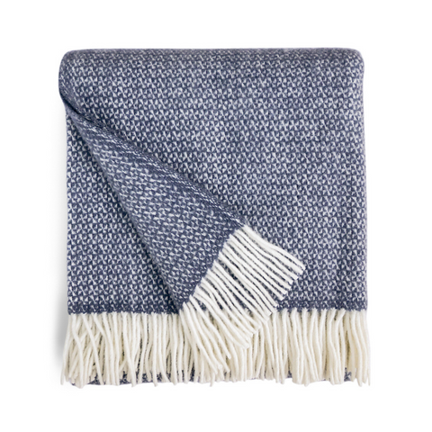 Picture of a folded Welsh wool throw in Slate Blue which is a medium shade of greyish blue. Off white tassels at both ends.