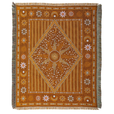 woven throw in shades of orange and brown with a moon and stars design and fringing on four sides